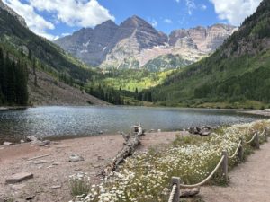 Maroon Bells Aspelin Snowmass shows trail, lake and maroon capped mountains in the distance