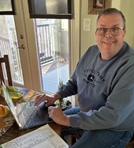 Paul Aspelin working on his laptop at the kitchen table