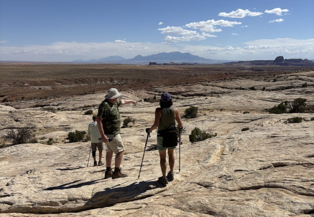 Hiking back from Wild Horse Window Natural Bridge over slickrock following piles of rock to mark the trail