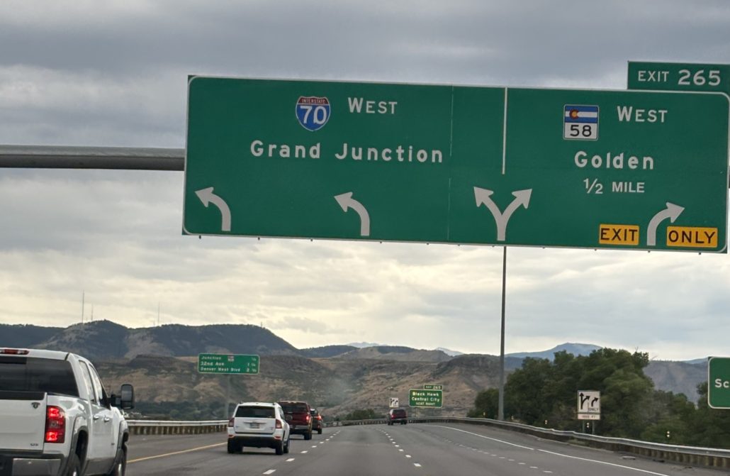 Overhead highway sign showing go west on I-70 to Grand Junction from Denver