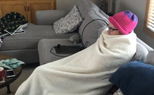 Michelle all bundled up with a blanket and hat during a Minnesota winter
