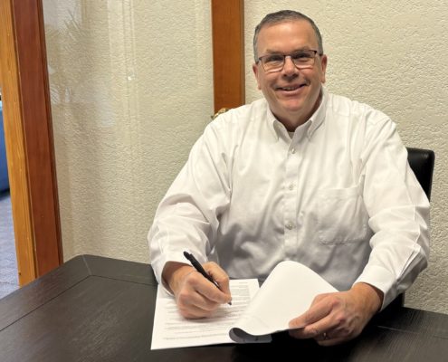 Paul Aspelin signing contracts at the office