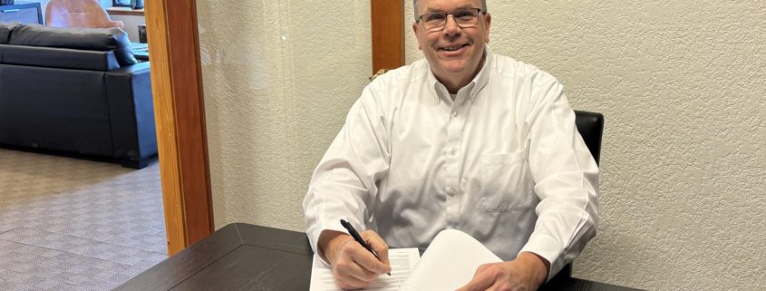 Paul Aspelin signing contracts at the office
