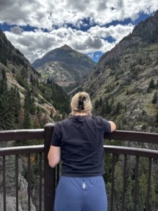 Megan looking out to the Million Dollar Highway in the San Juan Mountains at the Bear Creek waterfall
