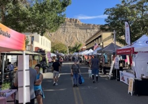 Palisade Farmers Market showing booths and Mount Garfield in the backdrop